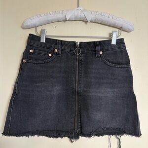 Free People black denim mini skirt with zipper and frayed hem. Size: 24